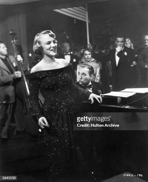 American singer, songwriter and actress Peggy Lee , performing in a scene from the film 'Mr Music', accompanied on the piano by Bing Crosby. The film...
