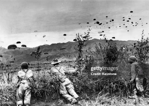 French parachutists watching comrades being dropped over Dien Bien Phu, an enemy stronghold which was captured by the paratroopers during the Indo -...