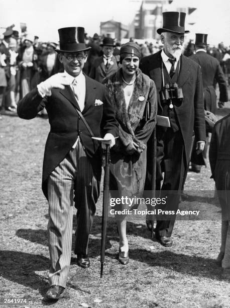 Banker Anthony Rothschild, , his wife and Lord d'Abernon walk to the paddock at the Oaks at Epsom, on Ladies' Day.