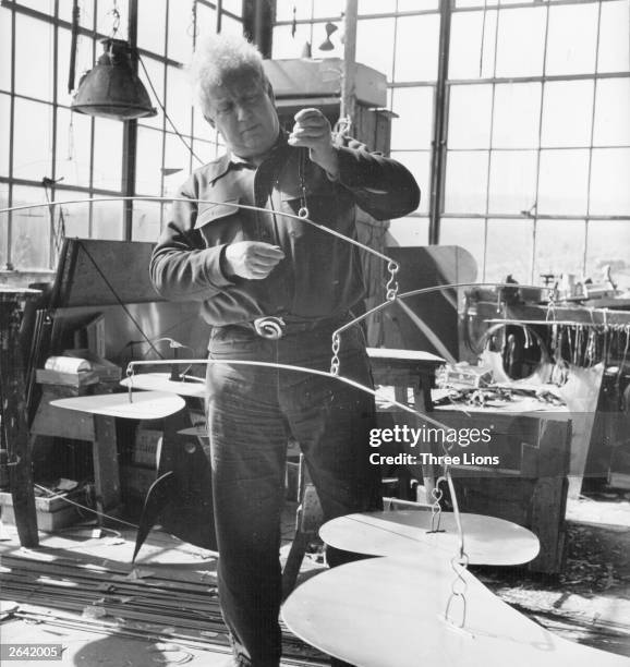 American artist Alexander Calder at work in his Connecticut studio where he turns sheets of iron into mobiles.