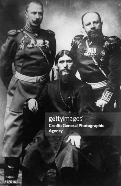 Russian peasant and mystic Grigory Yefimovich Rasputin , centre, former peasant and self-styled holy man, sitting between two military men in...