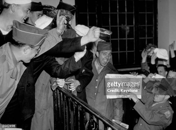 Servicemen in New York cheer the news that Hitler died in his Chancellery in Berlin.