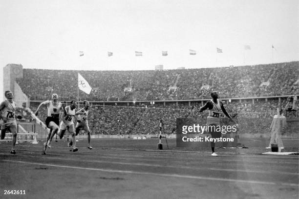 Jesse Owens of the USA crosses the finishing line to win the 100 metres at the 1936 Olympics in Berlin. He won three other gold medals, in the 200...