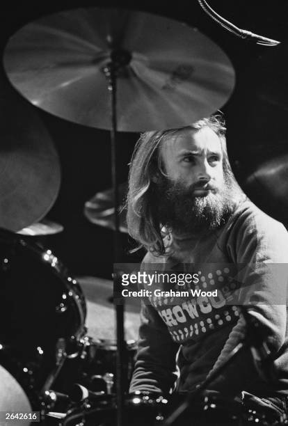 Phil Collins, drummer and singer with British rock band Genesis, takes a break behind his drum kit, while rehearsing at the Rainbow Theatre, London,...