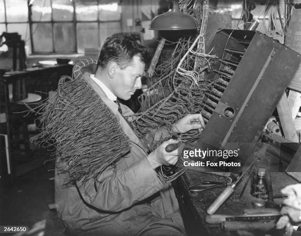An engineer at work at the General Post Office clock and telephone workshop in Holloway, London.