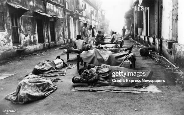 Homeless people asleep on the streets of Bombay.