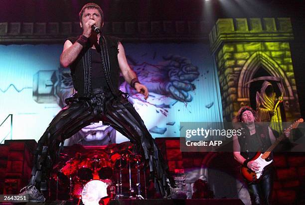 Bruce Dickinson of British Heavy Metal Band 'Iron Maiden' performs on stage next to Adrian Smith at Munich's Olympiahalle 24 October 2003. The act is...