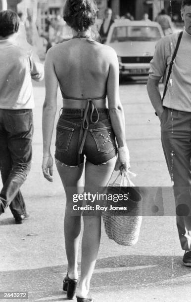 Woman wearing cut-off jeans and a halter-neck sun top in St Tropez.