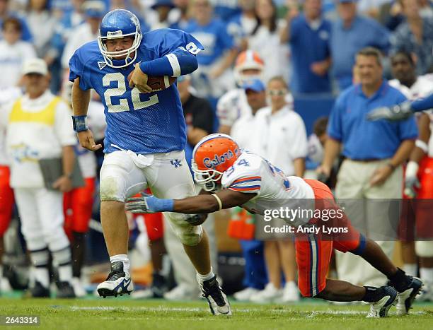 Jared Lorenzen of Kentucky runs with the ball while defended by Daryl Dixon of Florida on September 27, 2003 at Commonwealth Stadium in Lexington,...
