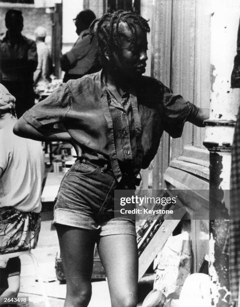 Woman wearing turned-up denim hot pants in Portobello Market, London.