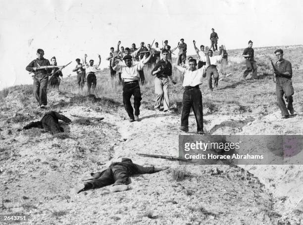 After a successful attack, Nationalist troops capture communist troops entrenched on the crest of a hill on the Somosierra front, during the Spanish...