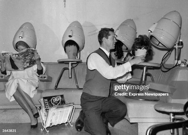 Hairdresser drying wigs under the salon's hairdryers.