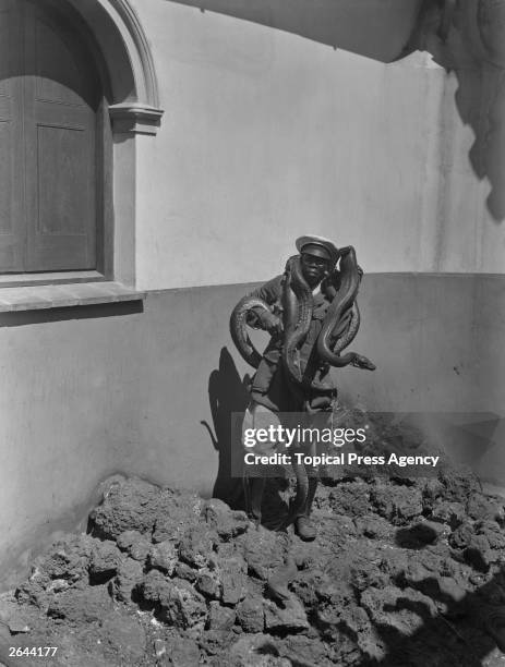 An attendant at the Snake Farm in Port Elizabeth, South Africa, with pythons wrapped around his neck.