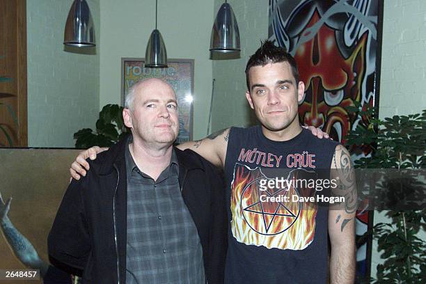 British pop star Robbie Williams signs his 80 million pound record contract with EMI Records head Tony Wadsworth at EMI Headquarters on October 2,...