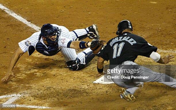 Alex Gonzalez of the Florida Marlins scores on Luis Castillo single as Jorge Posada of the New York Yankees can't apply the tag in the fifth inning...