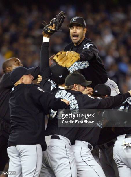 Mike Lowell of the Florida Marlins jumps on top of the pile of his teammates after defeating the New York Yankees 2-0 to win game six of the Major...
