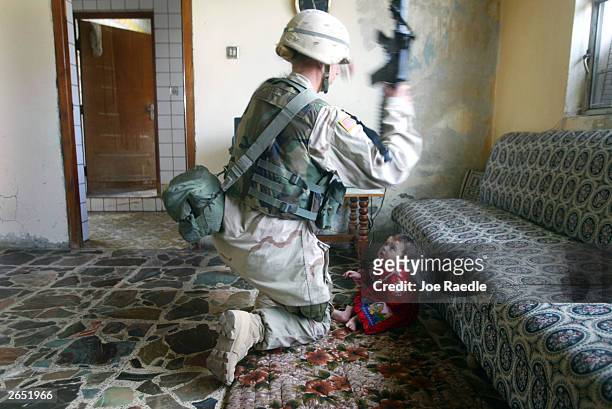 Army sergeant Lisa Juve from Bismarck, North Dakota of the 720 Military Police Battalion attached to the Fourth Infantry Division picks up an Iraqi...