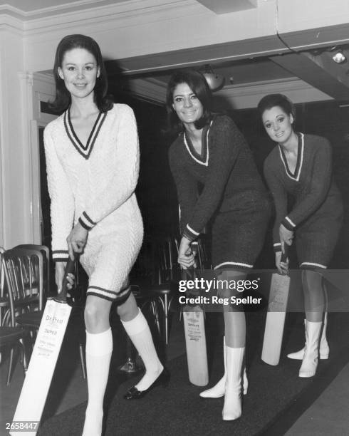 Three models wearing hand-knitted Burberry cricket sweater dresses.