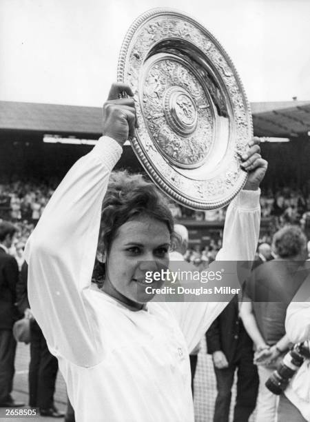 Australian tennis player Evonne Goolagong holding aloft the Wimbledon trophy after her victory over Margaret Court in two sets; 6-4, 6-1. Original...