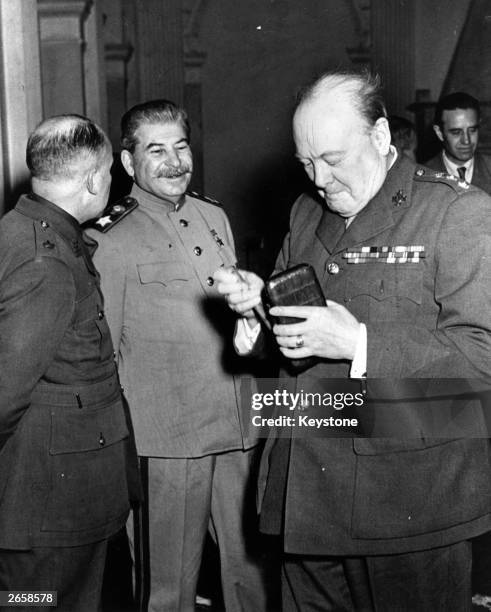 Winston Churchill , the British prime minister, takes a new cigar as Joseph Stalin the Soviet leader smiles with approval at the Crimea conference,...