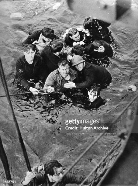 Crew members of the French destroyer Bourrasque, sunk by mine off Nieuwpoort during the Dunkirk evacuation, are hauled aboard a British vessel from...