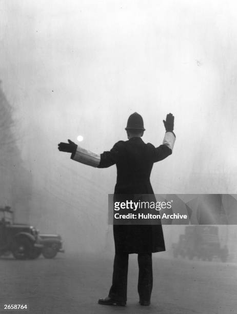 Policeman on traffic duty on a foggy day in Fleet Street, London.