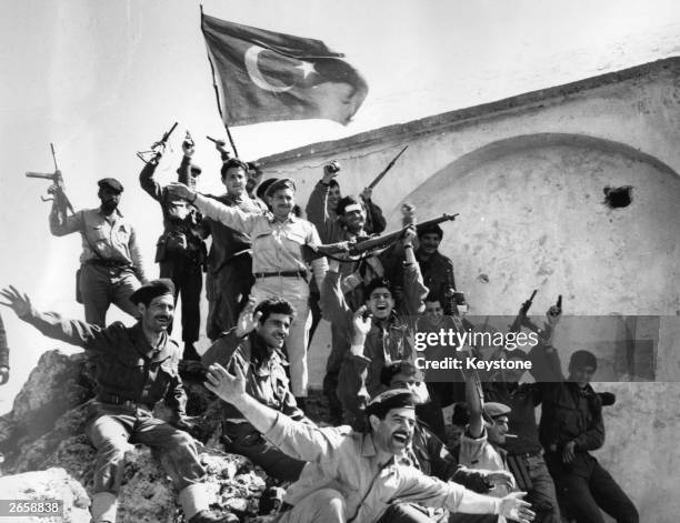 Jubiliant Greek Cypriot insurgents with a captured Turkish flag after seizing the strategic heights of St Hilarion Castle above Kyrenia during...