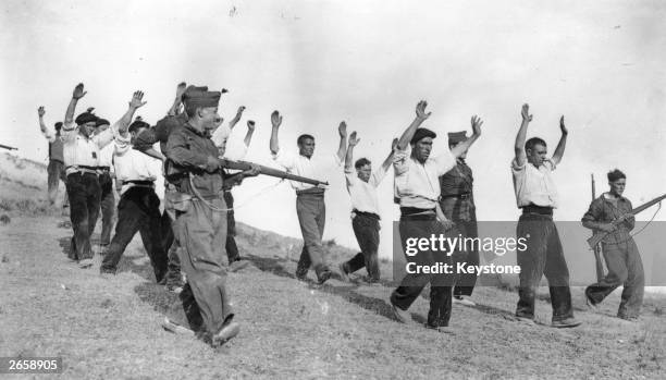 Nationalist troops escorting a group of captured Republican troops on the Samosierra front during the Spanish Civil War.