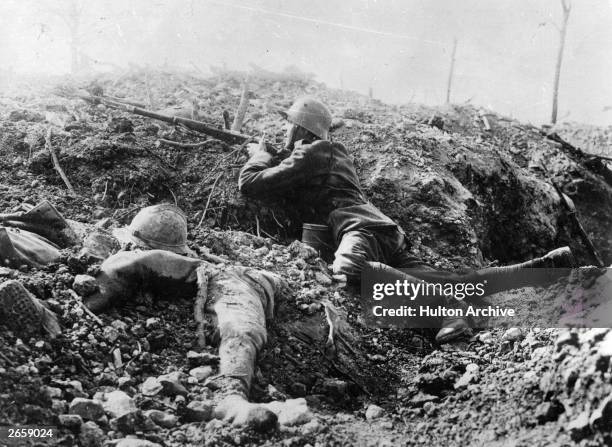 German rifleman beside the corpse of a French soldier in a trench at Fort Vaux, France.