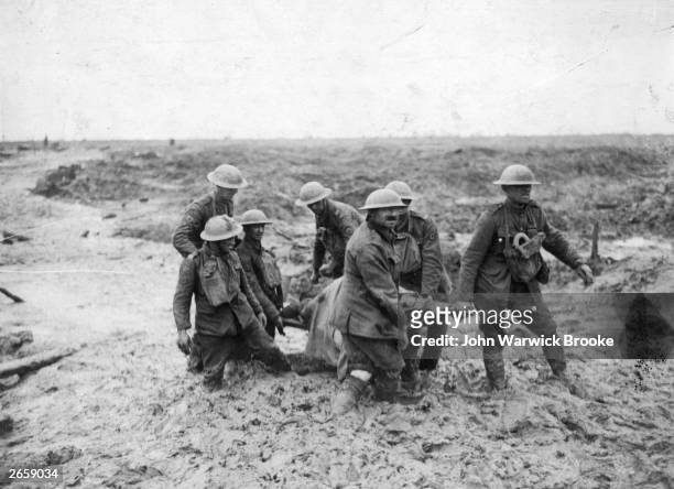 Stretcher-bearing party carrying a wounded soldier through the mud near Boesinghe during the battle of Passchendaele in Flanders.