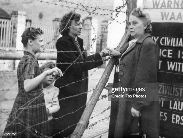 Dutch woman seeing her daughter and grandchildren through the barbed wire fence which divides the mining town of Kerkrade in two on the Dutch-German...