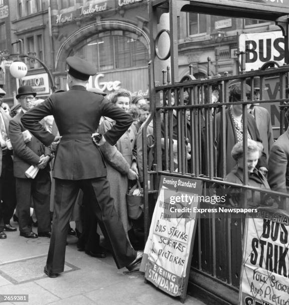 Policeman controls queues at Tottenham Court Road underground station during a strike by London buses.