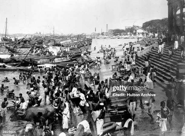 International traders and Indians jostle for space, bathing, cooking and collecting water, in the port of Calcutta.