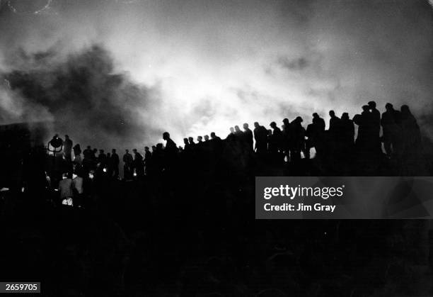 Rescue workers toil into the night under floodlights at the Welsh mining village of Aberfan, after a landslide buried the local school, killing over...