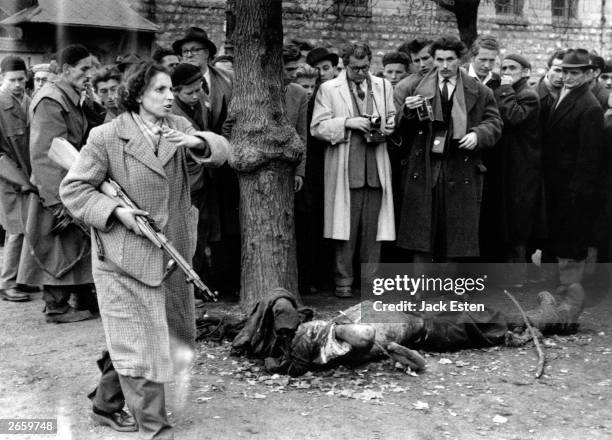 The body of a member of the Hungarian secret police lies in a Budapest street as western journalists witness the anti-communist uprising in Hungary....