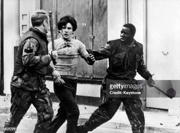 Teenage civilian is arrested by British troops during a civil rights demonstrations in Belfast.