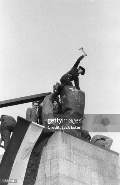 Hungarian demonstrators dismantling the boots of a giant statue of Stalin in Budapest. Original Publication: Picture Post - 8730 - Hungary's Last...