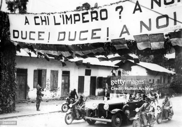 The arrival of Italian official Lessona Cobolli Gigli in Italian-occupied Addis Ababa. The slogan on the banner reads: 'To whom does the empire...