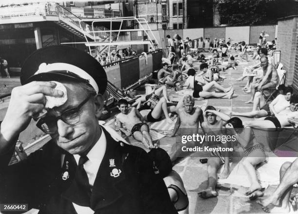 An ambulance man on duty at the Holborn Oasis swimming pool, London, suffering in the July heat.