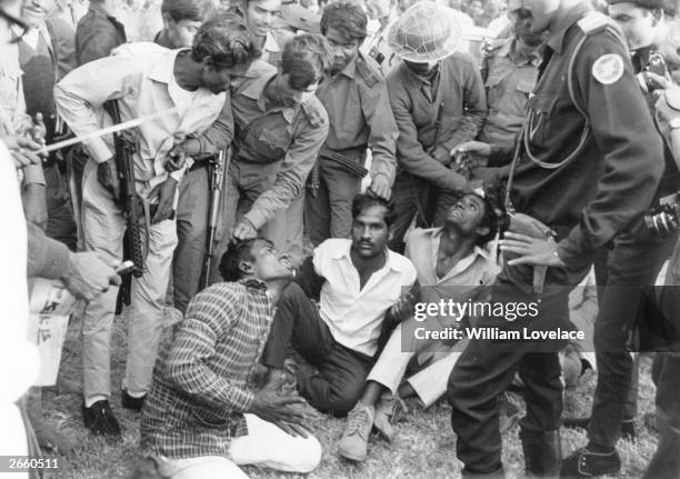 Guerrilla fighters of the pro-independence Mukti Bahini forces preparing to torture and execute four men accused of being members of the...