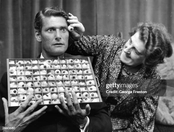 Jane Jackson, an employee of Madame Tussaud's, London, selecting a matching eye for disc jockey Pete Murray's waxwork model.