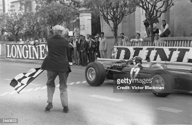 Jackie Stewart taking the checkered flag to win the Monaco Grand Prix.