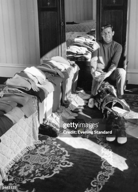 Golfer Doug Sanders sitting in his dressing room surrounded by the outfits he wore at Hoylake.