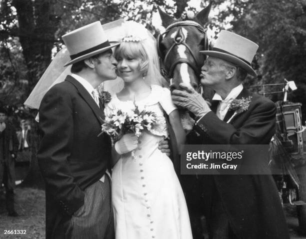 Wilfrid Brambell kissing a horse and Harry H Corbett kissing the bride, in a scene from the television series 'Steptoe and Son'.