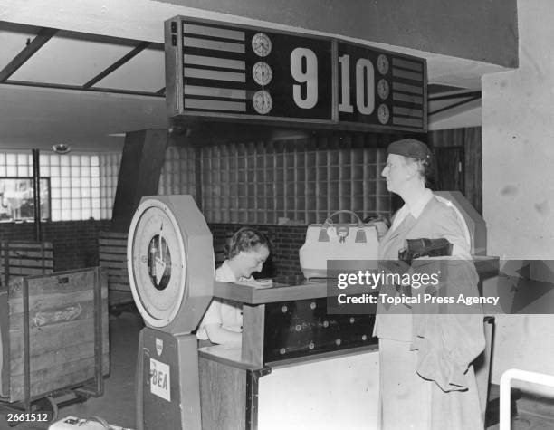 Woman checks her baggage in at Waterloo Air Terminal in London, before flying to Paris.