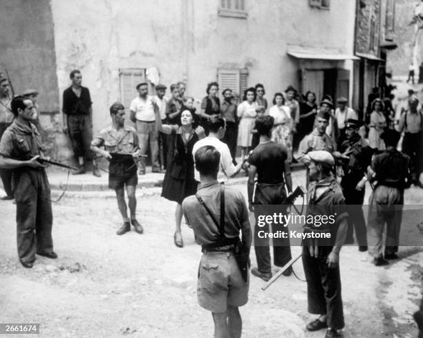 Two French spies, , denying charges of having acted as informers for Nazi Gestapo to a crowd of hostile onlookers in a French village.