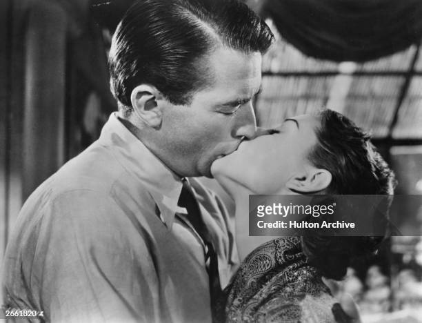 Gregory Peck and Audrey Hepburn kissing in the film 'Roman Holiday', directed by William Wyler.