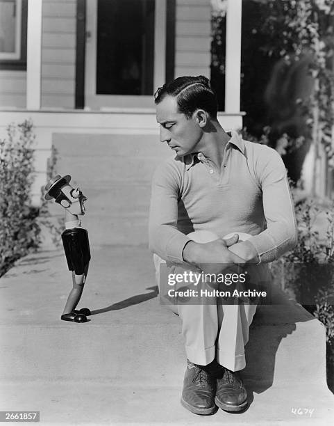 Buster Keaton , silent comedy film star, with a wooden doll of himself, given to him as a gift by a German woodcarver.