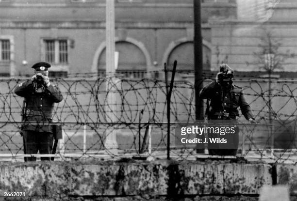 East German guards watching over the Berlin wall during Queen Elizabeth and Prince Philip's visit to the city on May 29, 1965.