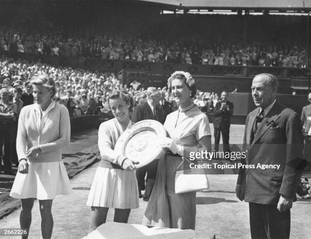 American tennis player Maureen Connolly receives the women's singles trophy from the Duchess of Kent on the centre court at Wimbledon, after beating...